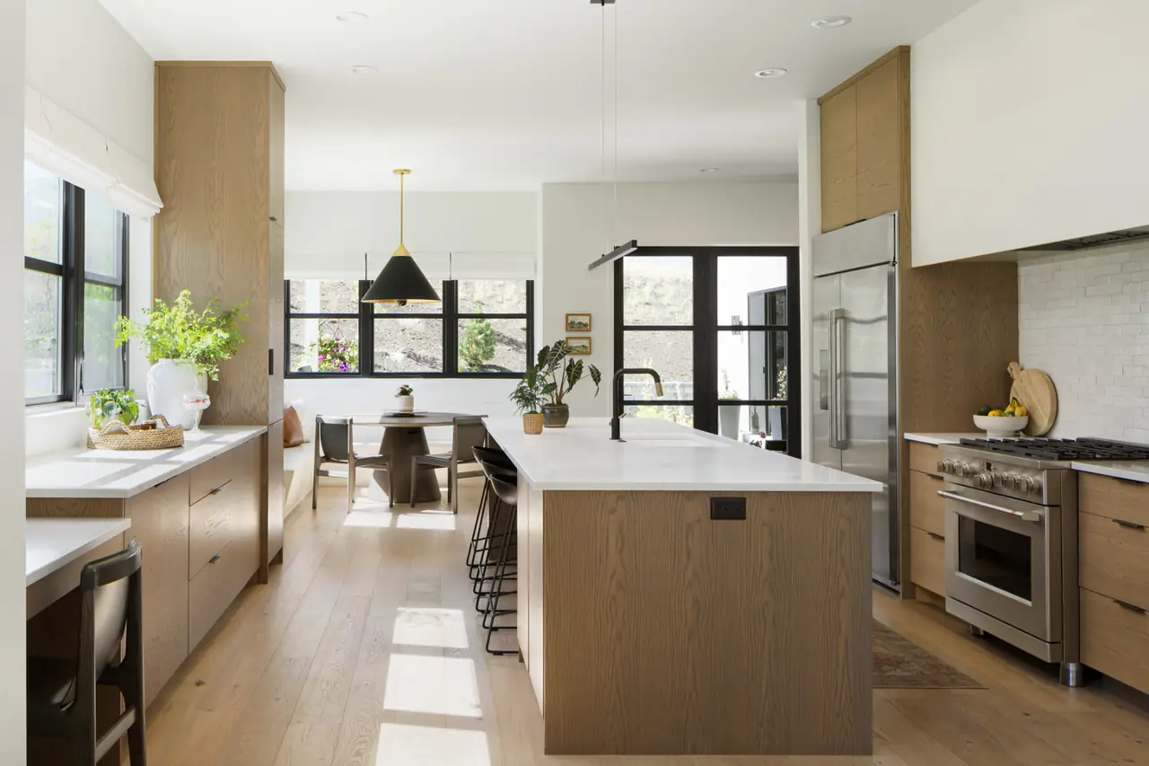 Custom kitchen with wood cabinetry, white countertops, and an island